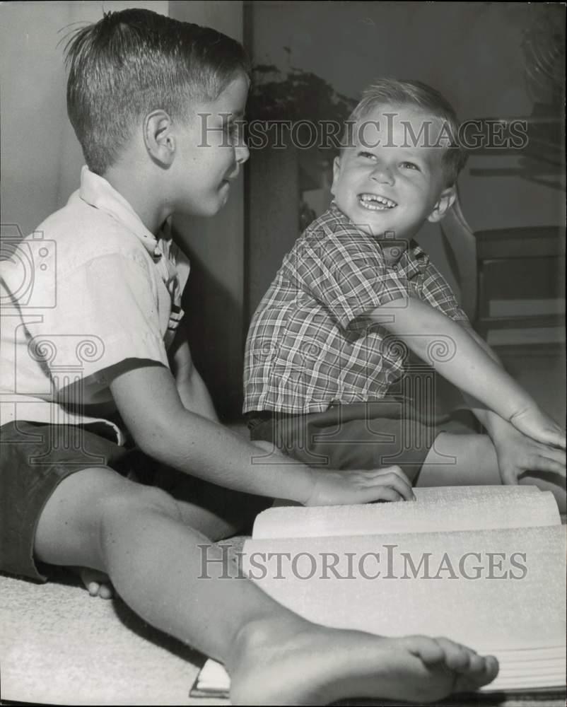 1958 Press Photo A youngster laughs with a boy while reading a braille book